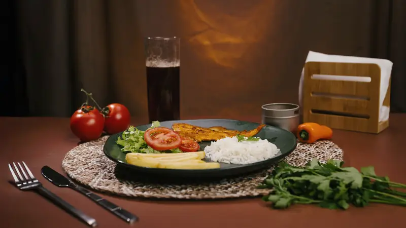Assiette de riz, de légumes et de crudités servie à table