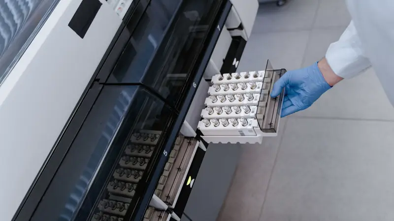 Technicienne de laboratoire devant un automate d'analyses