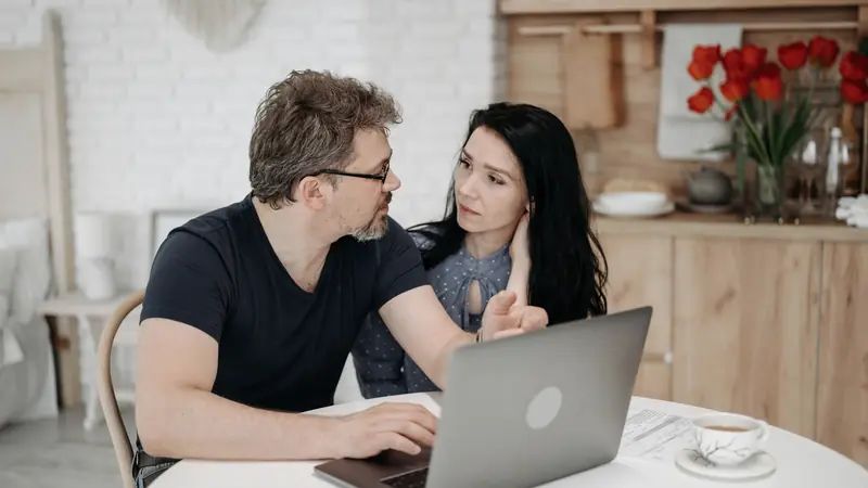 Couple qui consulte des offres sur un ordinateur portable