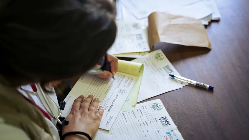 Personne qui remplit des formulaires sur une table
