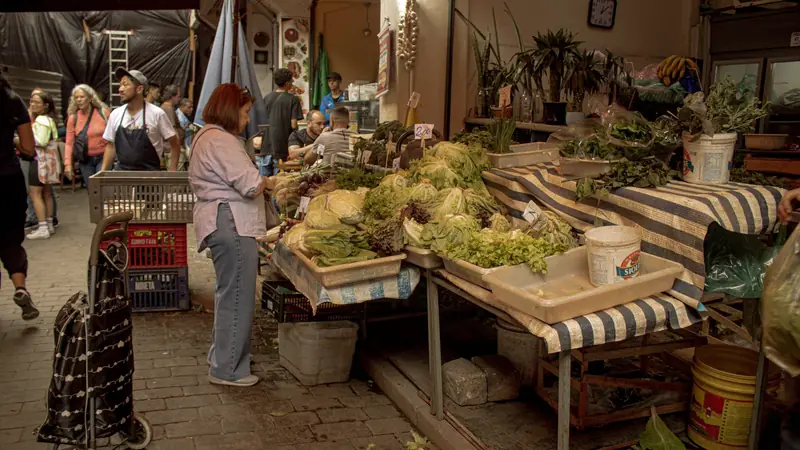 Personne qui fait son marché au rayon fruits et légumes