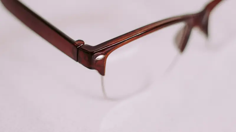 Gros plan sur la charnière et le cerclage d'une monture de lunettes de vue écaille brune