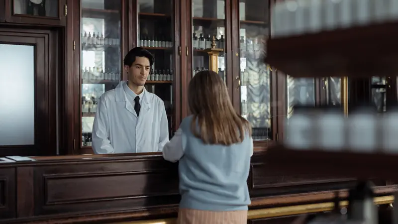Pharmacienne qui conseille une cliente au comptoir