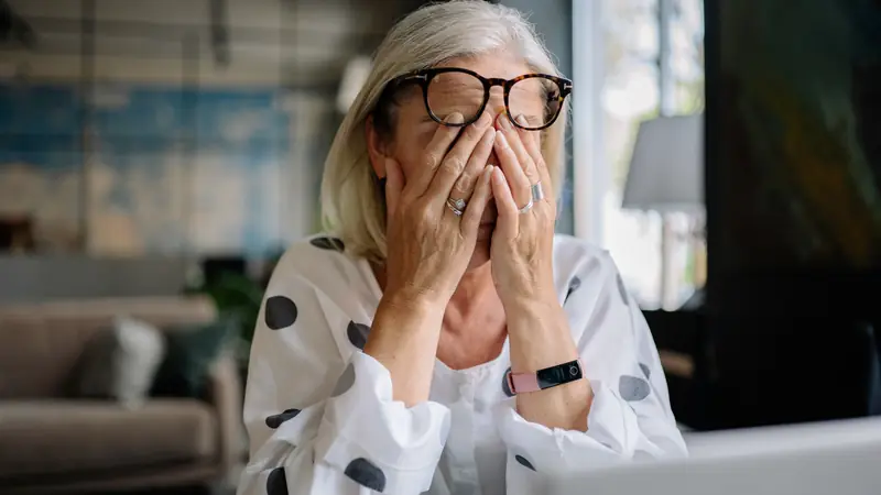 Femme fatiguée qui se frotte les yeux devant un ordinateur