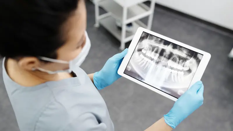 Praticienne qui examine une radiographie dentaire sur une tablette