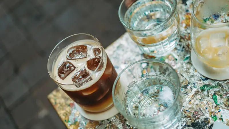 Verres d'eau et boissons fraîches avec des glaçons posés sur une petite table
