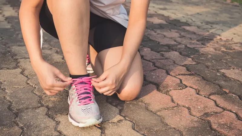 Femme qui lace ses chaussures de sport avant une séance