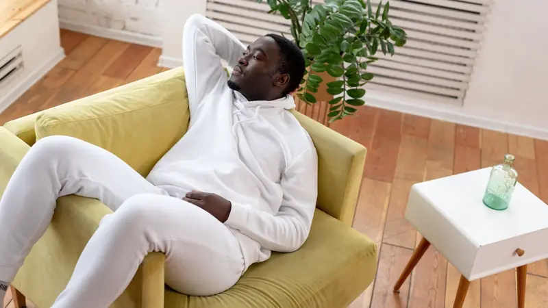 Homme qui se repose dans un fauteuil jaune