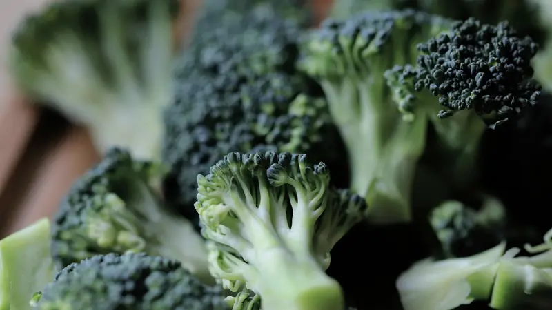 Gros plan de bouquets de brocoli frais sur une planche à découper en bois